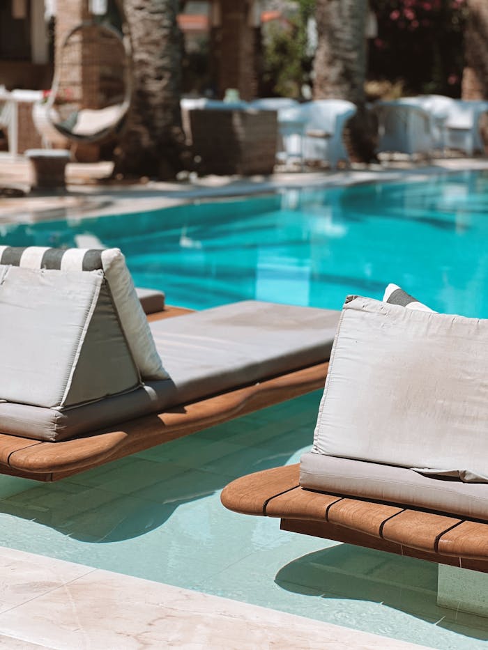 Relax and unwind by a beautifully sunlit pool with inviting sunbeds and turquoise water.